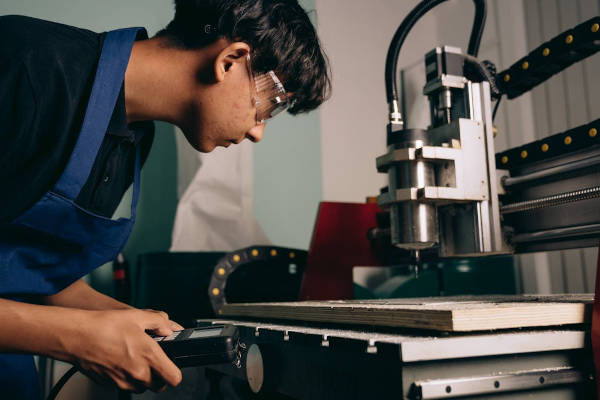 Young man using a CNC machine
